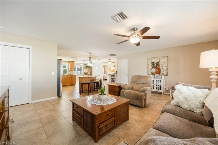 Living area featuring light tile patterned floors and ceiling fan