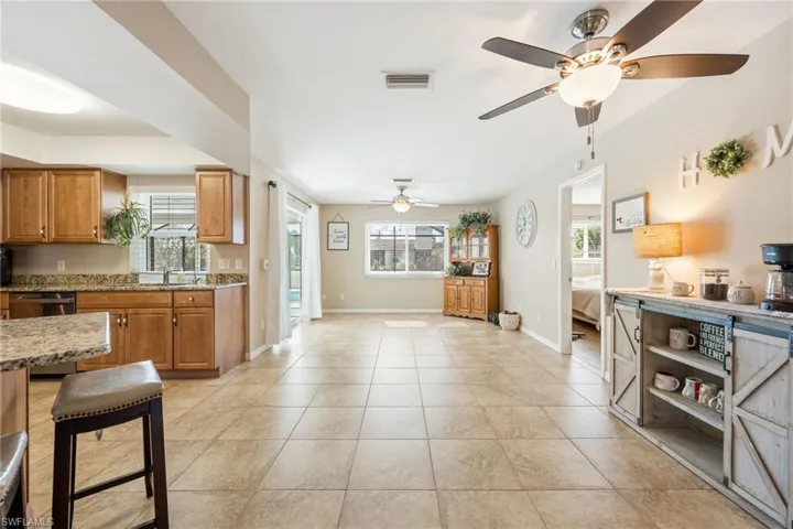 Kitchen featuring brown cabinetry, healthy amount of natural light, dishwasher, and light tile patterned flooring