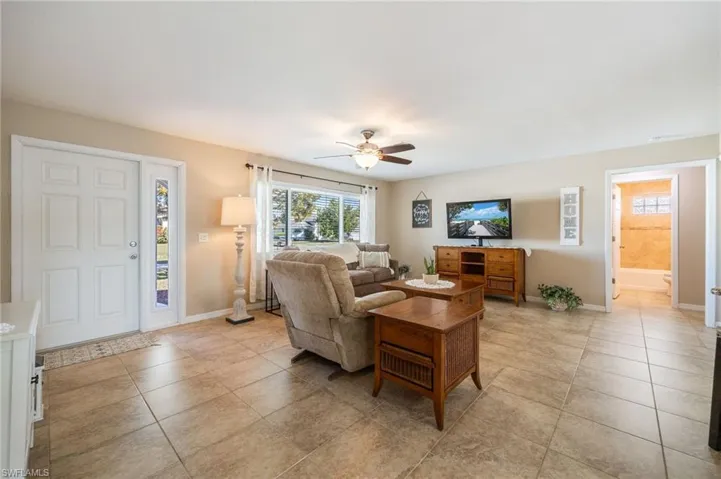 Living room featuring ceiling fan and light tile patterned floors