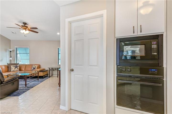 Kitchen looking into second living area, door to laundry room and garage, and microwave and oven