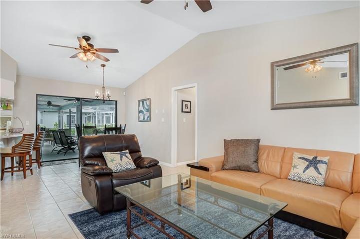 second living area, another dining area, bar seats at island, sliders to the lanai and pool - hallway to the other bedrooms and pool bath ( on right)