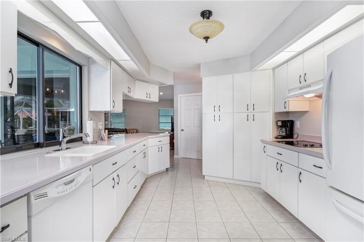large kitchen with views of the canal & pool, with bar area off island