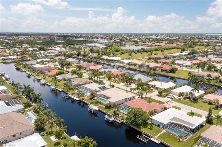 Back of the home with boat dock, seawall, and lift