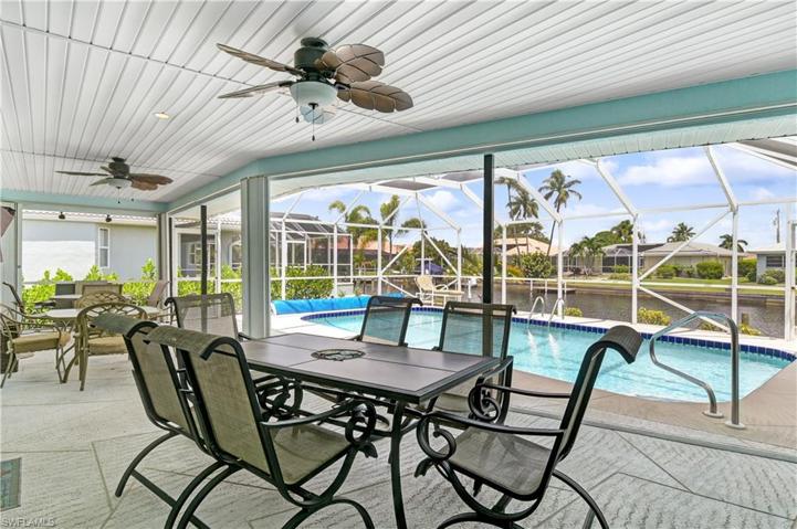 covered lanai space with seating - screened in pool area leads out to the boat dock