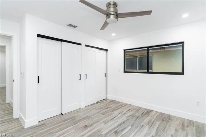 Unfurnished bedroom featuring multiple closets, light wood-style floors, a ceiling fan, and recessed lighting