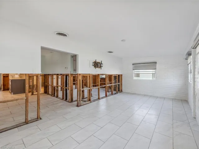 Unfurnished room featuring brick wall