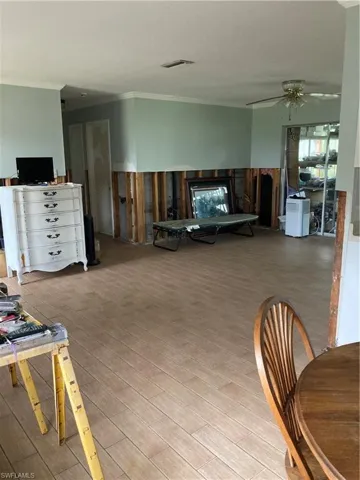 Living room featuring ceiling fan, light hardwood / wood-style floors, and crown molding