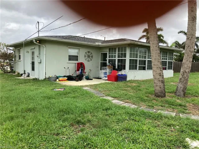 Rear view of property with a yard