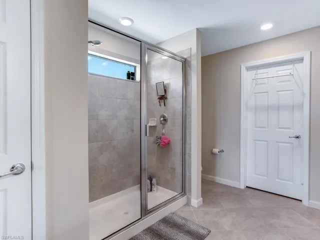 Bathroom featuring a shower with door and tile patterned floors