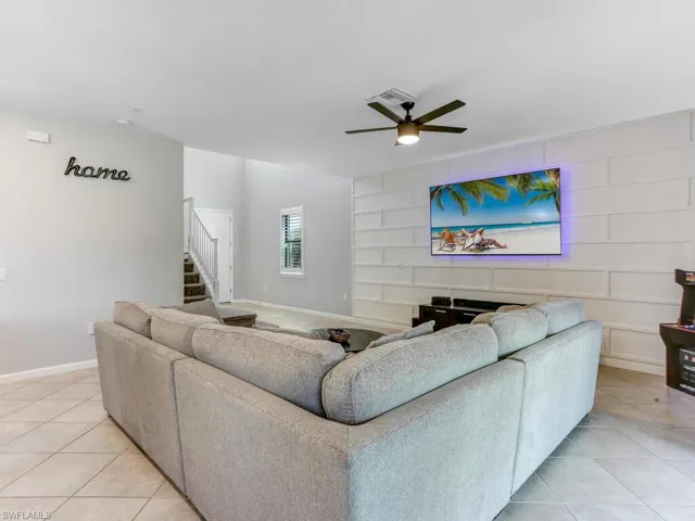 Living room with light tile patterned flooring and ceiling fan