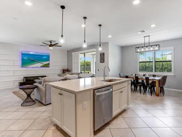 Kitchen featuring dishwasher, a kitchen island with sink, plenty of natural light, and sink
