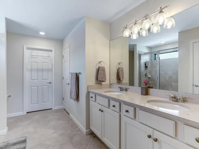 Bathroom featuring vanity, tile patterned flooring, and an enclosed shower