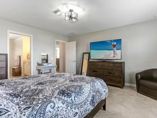 Tiled bedroom featuring ensuite bath