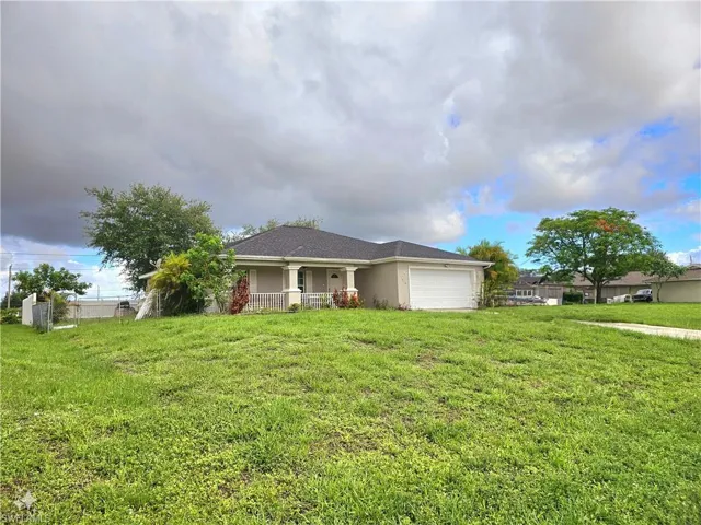 Ranch-style house with a front yard and a garage