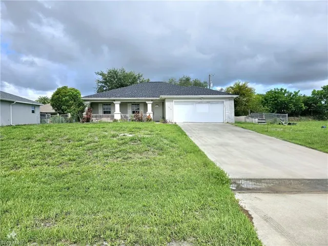 Single story home featuring a garage and a front yard