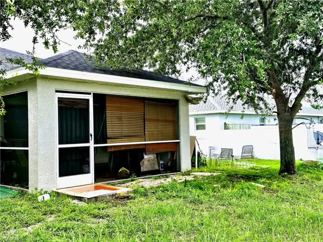 Back of property with a sunroom and a yard
