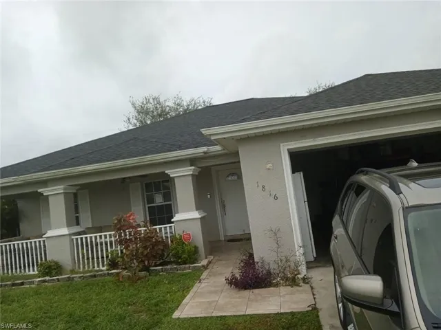 Property entrance with a porch and a garage