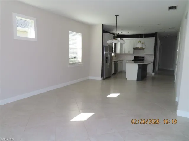 Kitchen featuring a center island, open floor plan, light countertops, white cabinetry, and stainless steel appliances