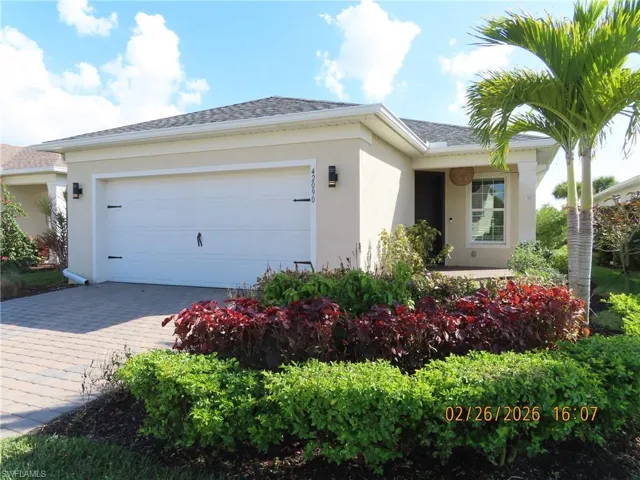 View of front of house featuring stucco siding, an attached garage, decorative driveway, and roof with shingles