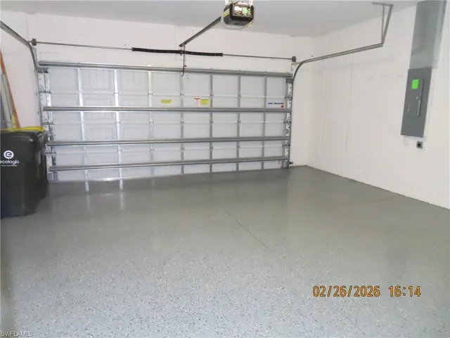 Garage featuring electric panel and a garage door opener