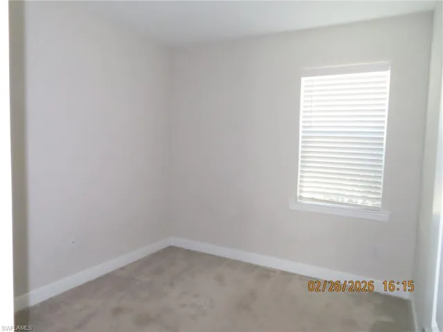 Unfurnished room featuring light colored carpet and plenty of natural light