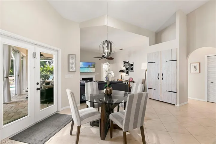 Tiled dining area with high vaulted ceiling and a notable chandelier