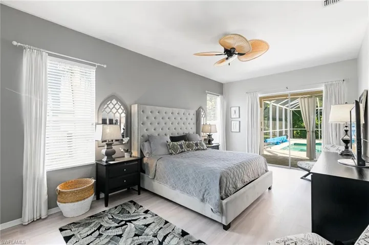 Bedroom featuring ceiling fan, light hardwood / wood-style floors, access to outside, and multiple windows