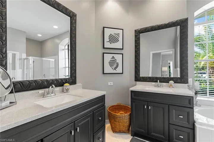 Bathroom with tile patterned floors, vanity, plus walk in shower, and a healthy amount of sunlight