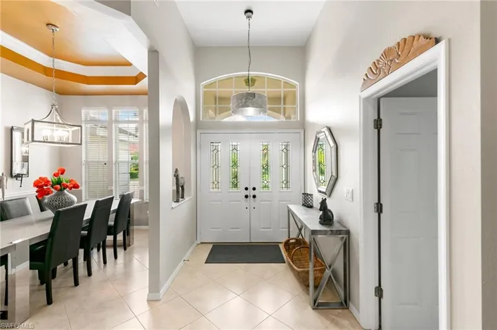 Foyer entrance featuring light tile patterned floors, a chandelier, and ornamental molding