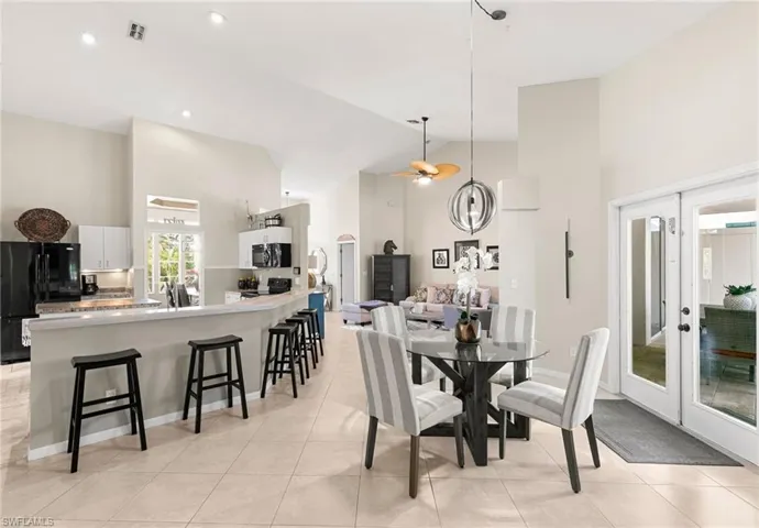 Tiled dining room with high vaulted ceiling and ceiling fan