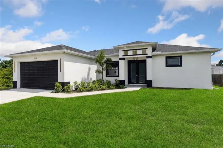 Prairie-style home with a front lawn, an attached garage, stucco siding, and french doors