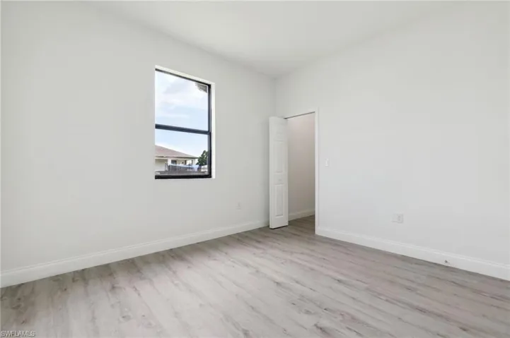 Empty room with light wood-style flooring and baseboards