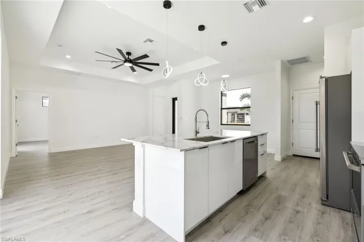Kitchen featuring stainless steel appliances, visible vents, and a sink