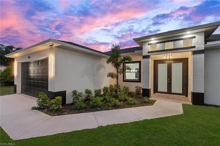 View of side of property with a garage and stucco siding