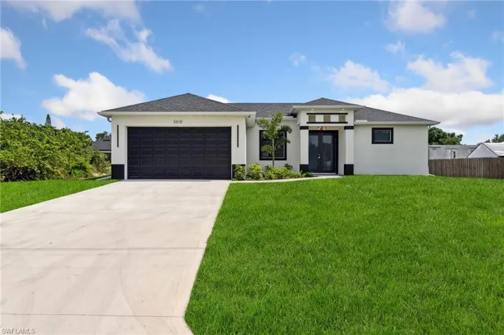 Prairie-style house featuring an attached garage, french doors, stucco siding, a front yard, and driveway