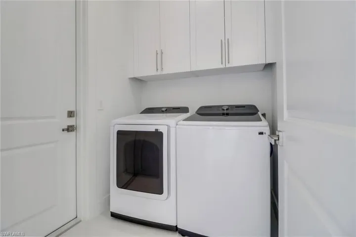 Laundry area featuring cabinet space and washing machine and dryer