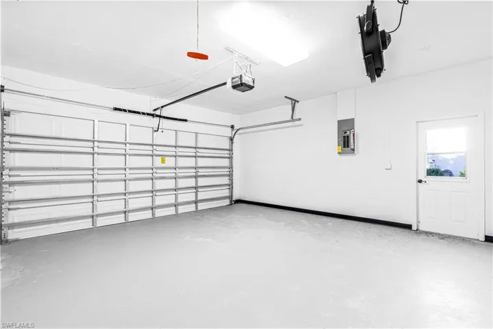 Garage featuring electric panel and a garage door opener