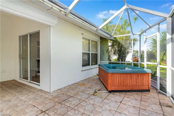 Sunroom featuring a patio area and a jacuzzi