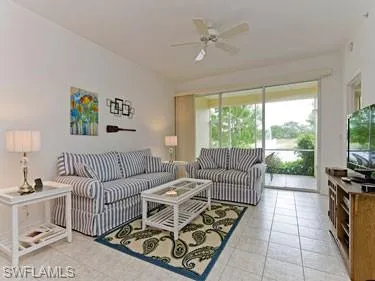 Living room featuring light tile patterned flooring and a ceiling fan
