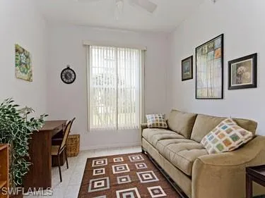 Living area with light tile patterned floors and a ceiling fan