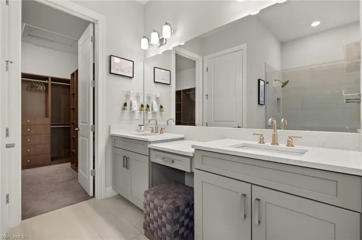 Primary bathroom featuring dual sinks and make up vanity area