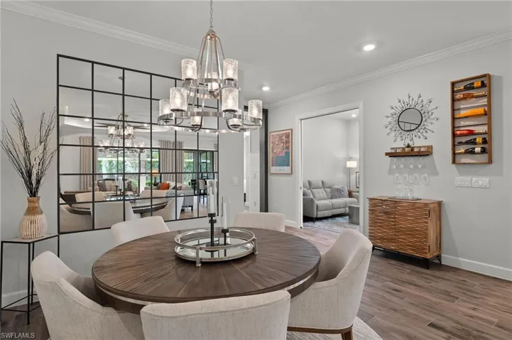 Dining space with mirror accent walls and crown molding