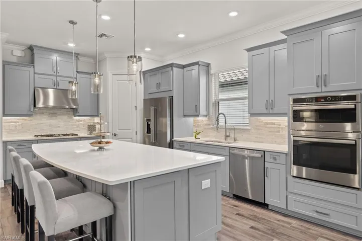 Kitchen with a kitchen island, appliances with stainless steel finishes, pendant lighting, gas cooktop