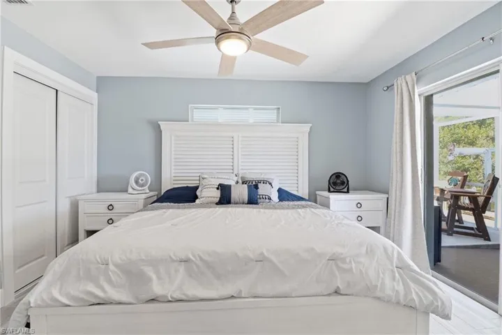 Primary Bedroom featuring access to outside, ceiling fan, en suite.