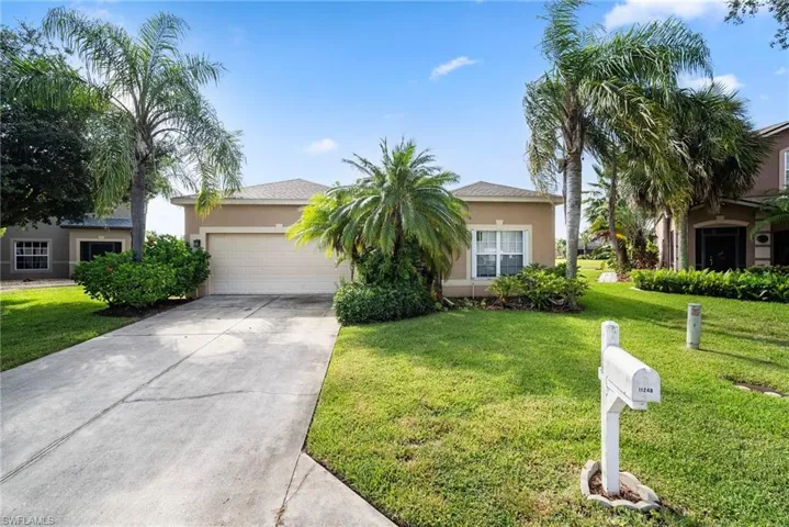 View of front of property with a front yard and a garage