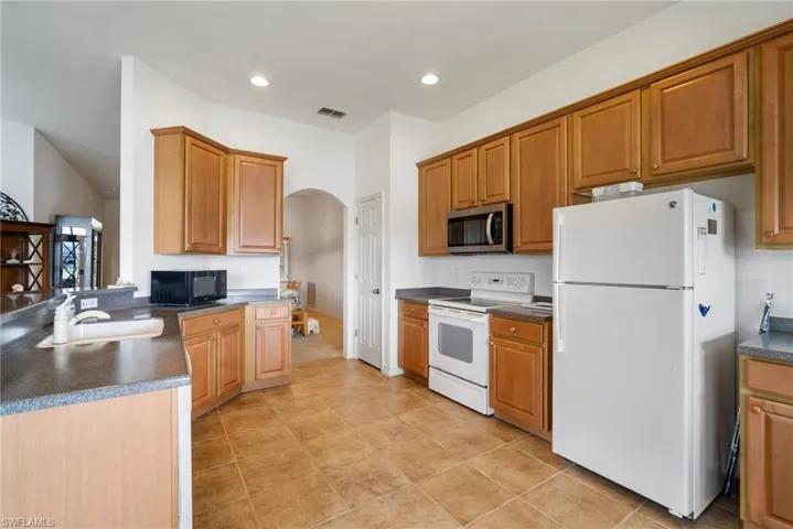 Kitchen with sink, white appliances, and light tile patterned floors