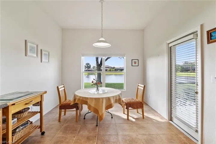 Dining area featuring light tile patterned floors and a water view