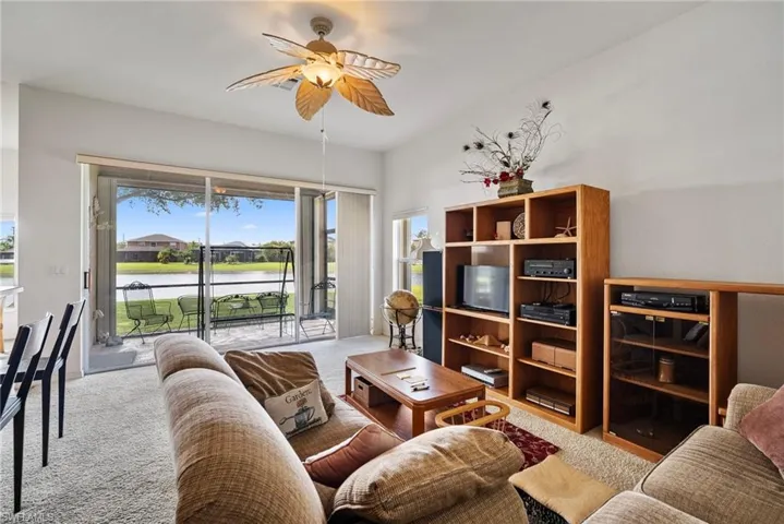 Carpeted living room with ceiling fan