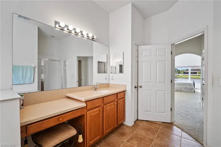 Bathroom with tile patterned flooring, vanity, and a shower with shower door