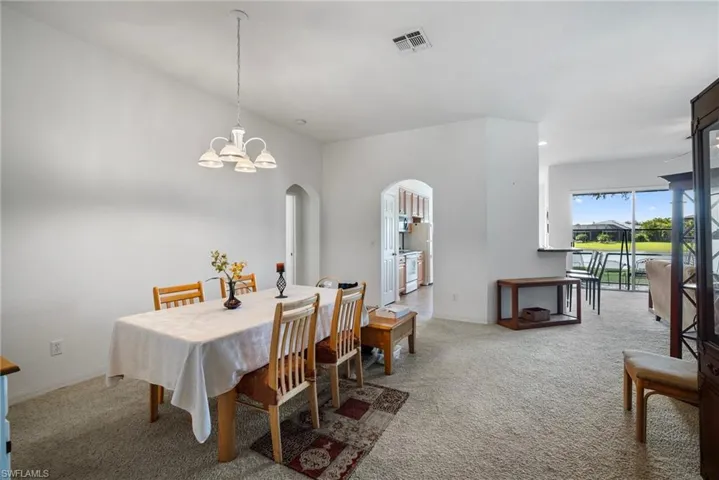 Carpeted dining room featuring an inviting chandelier